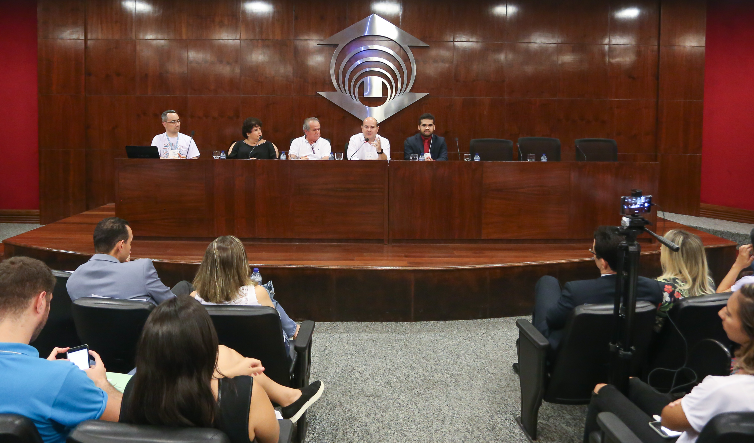 mesa de um auditório, mostrando os palestrantes